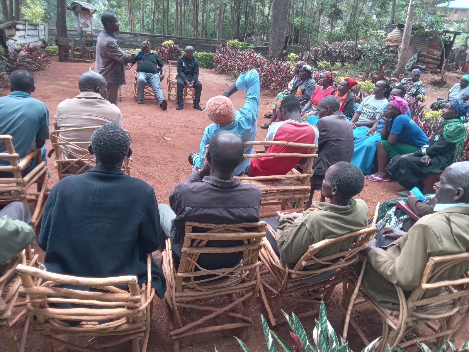 Members of the Itibo fellowship seated outdoors listening to a Bible teacher