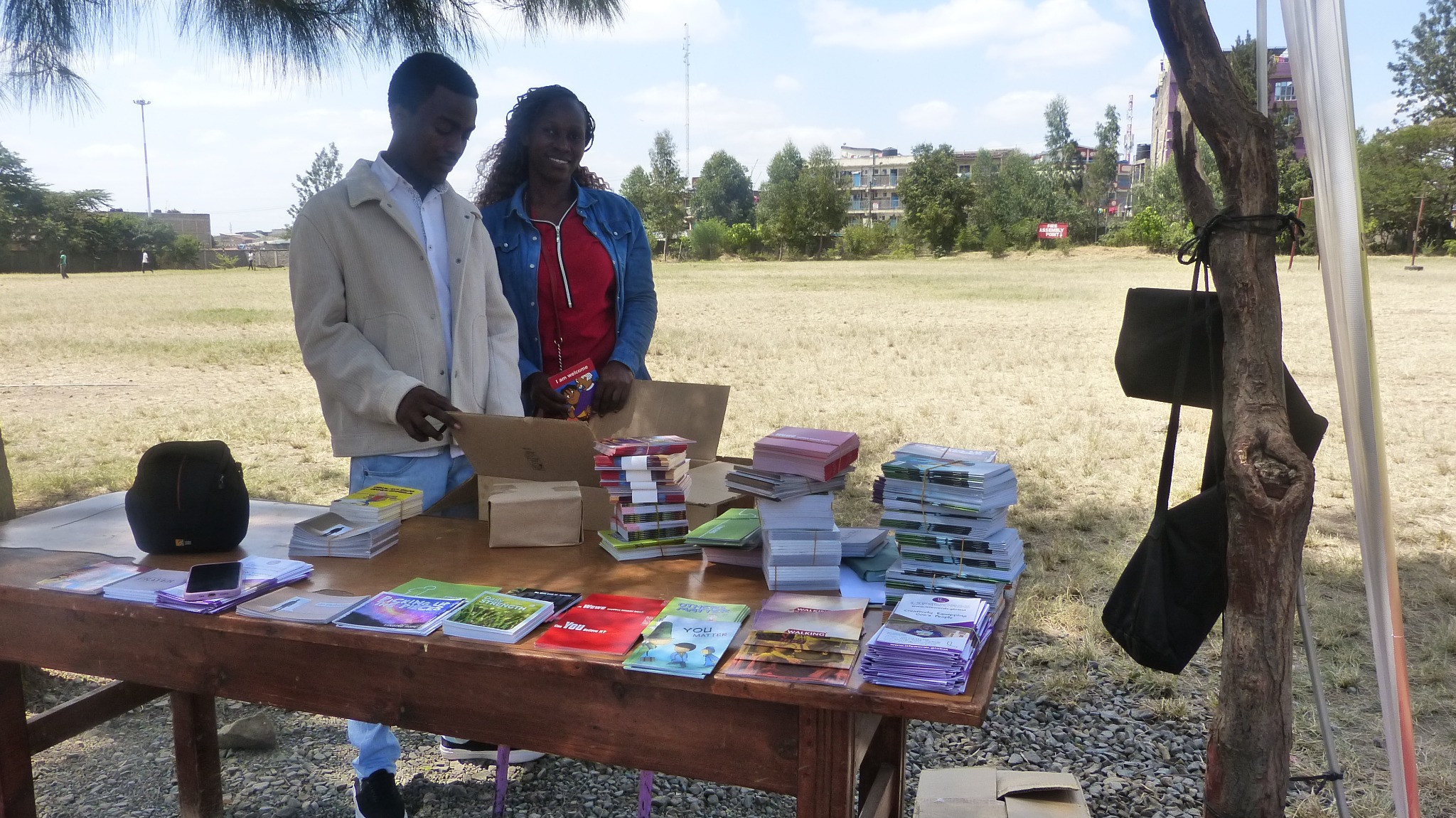 Lifewords workers arranging Bible resources on a table at an event in Kenya